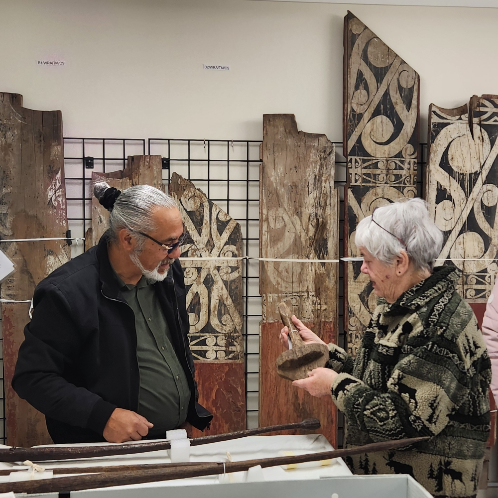 Museum visitors viewing and discussing collection items.